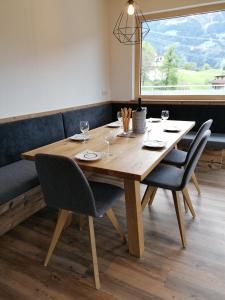 海因岑贝格Montepart Zillertal的一张带椅子的木桌和大窗户