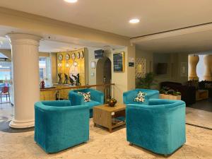 巴兰基亚Hotel American Golf的客厅配有2把蓝色椅子和桌子