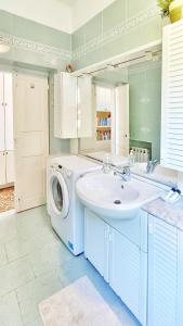 卡莫利Villa Mortola的一间带洗衣机和水槽的浴室