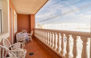 埃尔卡沃德加塔Stunning Apartment In Cabo De Gata With Kitchen的阳台配有白色椅子和大窗户。