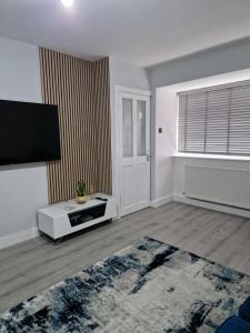 伦敦Stylish 2 bed home- short walk to Tottenham Stadium/Stations的带平面电视的空客厅