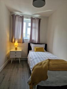 伦敦Stylish 2 bed home- short walk to Tottenham Stadium/Stations的一间小卧室,配有床和窗户