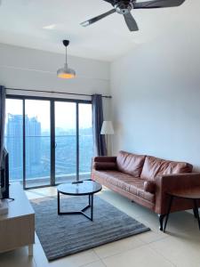吉隆坡Reizz Residence By Leo Suites的客厅配有棕色皮沙发和桌子
