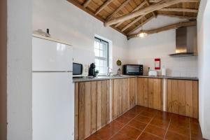 LajidoAdega Maciel的厨房配有木制橱柜和白色冰箱。