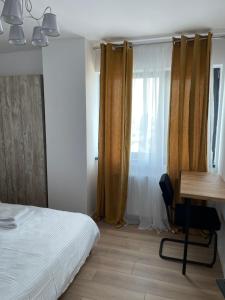 特尔古穆列什Best View Terrace的一间卧室配有一张床、一张书桌和一个窗户。