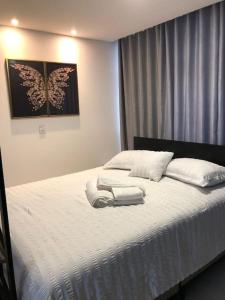 波梅罗迪Lindo Flat Central - Home Business的卧室配有白色床和毛巾