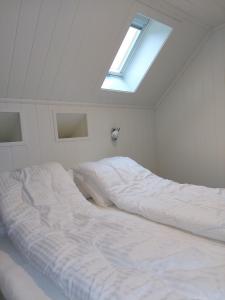 FedaSouthern bliss - Sørlandsidyll的白色卧室设有一张带天窗的大床