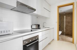 新加坡The Majestic Mile 1BR Apartment in Singapore!的白色的厨房配有水槽和微波炉