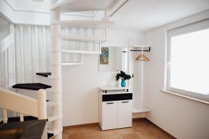 海特斯海姆Idylische Ferienunterkunft的白色的窗户房间内的白色螺旋楼梯