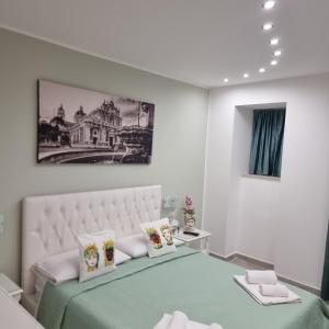 卡塔尼亚Al Punto Giusto的白色卧室配有一张带绿毯和枕头的床