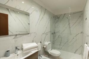 锡拉库扎埃尔多莫酒店的白色的浴室设有卫生间和水槽。