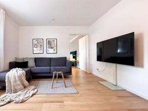 斯图加特Appartio: Geräumige, moderne Ferienwohnung für Gruppen/Familien的客厅配有蓝色的沙发和平面电视。