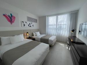 好莱坞Hyde Beach House Lux Apartment的酒店客房设有两张床和一台平面电视。