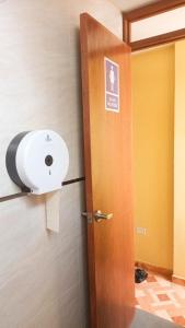 利马Confortable habitación doble frente al Aeropuerto的浴室门和墙上的卫生纸分配器