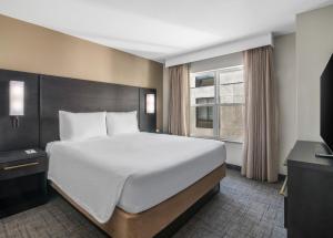 格伦代尔凤凰城格伦代尔体育娱乐区住宅旅馆的一间卧室设有一张大床和一个窗户。