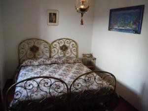 赫拉弗多纳Gravedona Village House的卧室内的一张床铺,配有锻铁床架
