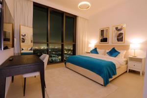 迪拜Stunning Apartment with Direct access to Dubai Mall的一间卧室配有一张床、一张书桌和一个窗户。