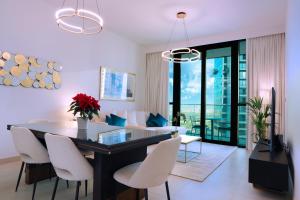迪拜Stunning Apartment with Direct access to Dubai Mall的用餐室以及带桌椅的起居室。
