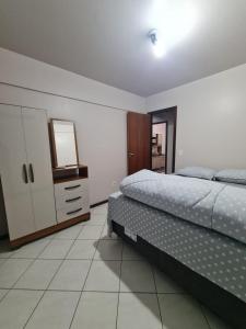 弗朗西斯科贝尔特朗Apartamento com mobília nova 201!的一间卧室配有一张床、梳妆台和电视。