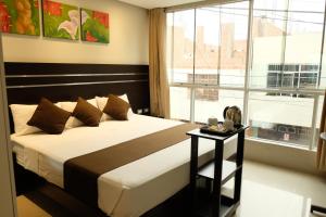 塔克纳Hotel Puma'r Tacna的一间卧室设有一张床和一个大窗户