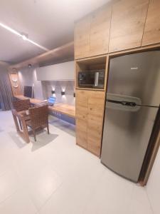 巴西利亚Vision Executive Premium Esplanada的一间带不锈钢冰箱的厨房和一间卧室