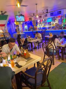 卡塔海滩San Antonio Beach Guesthouse & Restaurant的一群坐在餐厅桌子上的人