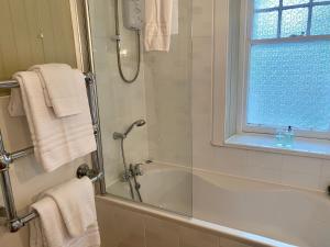 奥本阿兹住宿加早餐旅馆的带淋浴和浴缸的浴室以及窗户。