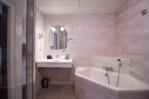 贝亨奥普佐姆德拉科住宿大酒店的带浴缸、水槽和浴缸的浴室
