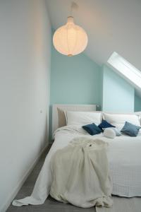 汉诺威Luxuriöses Messe Apartment an der Leineinsel in Hannover, direkt am Wasser in ruhiger Laage的卧室配有白色床和蓝色的墙壁
