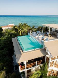 图卢姆哈西塔酒店的享有带游泳池和大海的房屋的空中景致