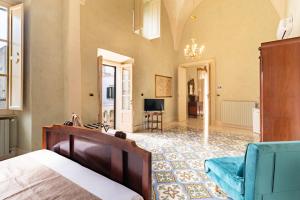 加利波利Palazzo Zacà的一间卧室配有一张床、一张沙发和一台电视