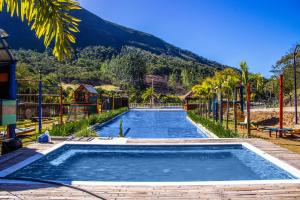 特雷索波利斯Art Green Teresópolis的一座大游泳池,后面是一座山