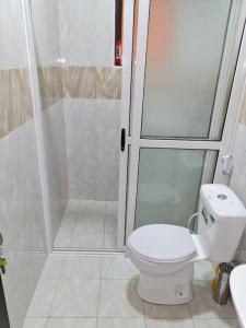 坎帕拉Cozy Apartment in Kololo的浴室配有白色卫生间和淋浴。