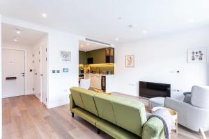 伦敦Modern Chelsea Apartment的客厅配有沙发和两把椅子