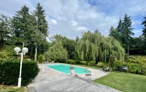 PrémilhatLe moulin de la Vernoelle的花园内的游泳池,配有桌椅