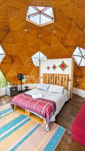 拉维加Glamping Reserva del Roble的卧室设有一张木制天花板上的大床