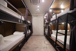 马六甲Sleep Here Hostel, Melaka的公共汽车上带三张双层床的房间