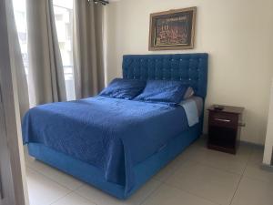 圣地亚哥Yolier Suites的卧室内的蓝色床和蓝色棉被