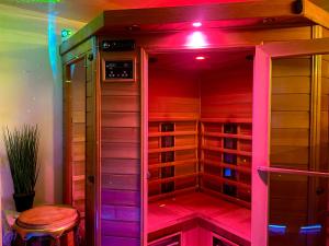 GagnyEspace détente jacuzzi sauna的配有紫色灯和凳子的步入式衣柜
