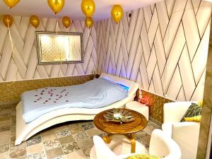 GagnyEspace détente jacuzzi sauna的一间设有一张床、一张桌子和气球的房间