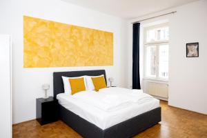 维也纳Premium 80 m2 Apartment - 5 min to Center - Free Parking的一间卧室配有一张带黄色枕头的大床