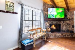 大熊湖Winter Getaway Spa Fire-table Close to slopes的客厅设有石制壁炉和电视。
