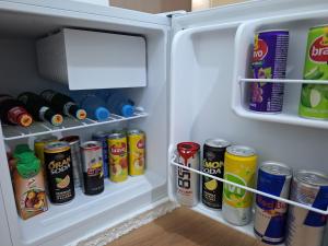 克鲁亚Ergi's Host Apartment的装满许多罐子和饮料的开放式冰箱