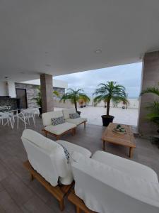 萨利纳斯Oasis Suite Salinas的客厅配有白色家具和棕榈树