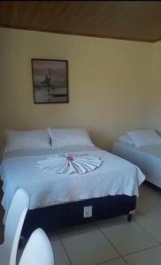 伊塔帕里卡岛维拉克鲁兹Flat - Condomínio Fechado - Frente Mar的卧室配有两张床,墙上挂着一幅画
