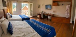 Coporaque阿兰瓦普鲁布里托恩坎塔德尔科尔卡酒店的酒店客房配有两张床、一张书桌和一张书桌。