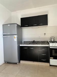 康考迪亚Nuevo apartamento en primer piso a 7 min del centro的厨房配有不锈钢冰箱和黑色橱柜