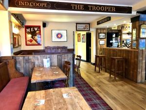 温莎The Windsor Trooper Pub & Inn的餐厅设有木桌、椅子和柜台