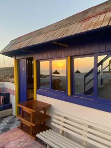 依索安LAFAMILIA SURF imsouane的屋顶上设有桌子和长凳的建筑