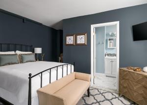 安纳波利斯Flag House Inn的卧室拥有蓝色的墙壁,配有一张床和椅子